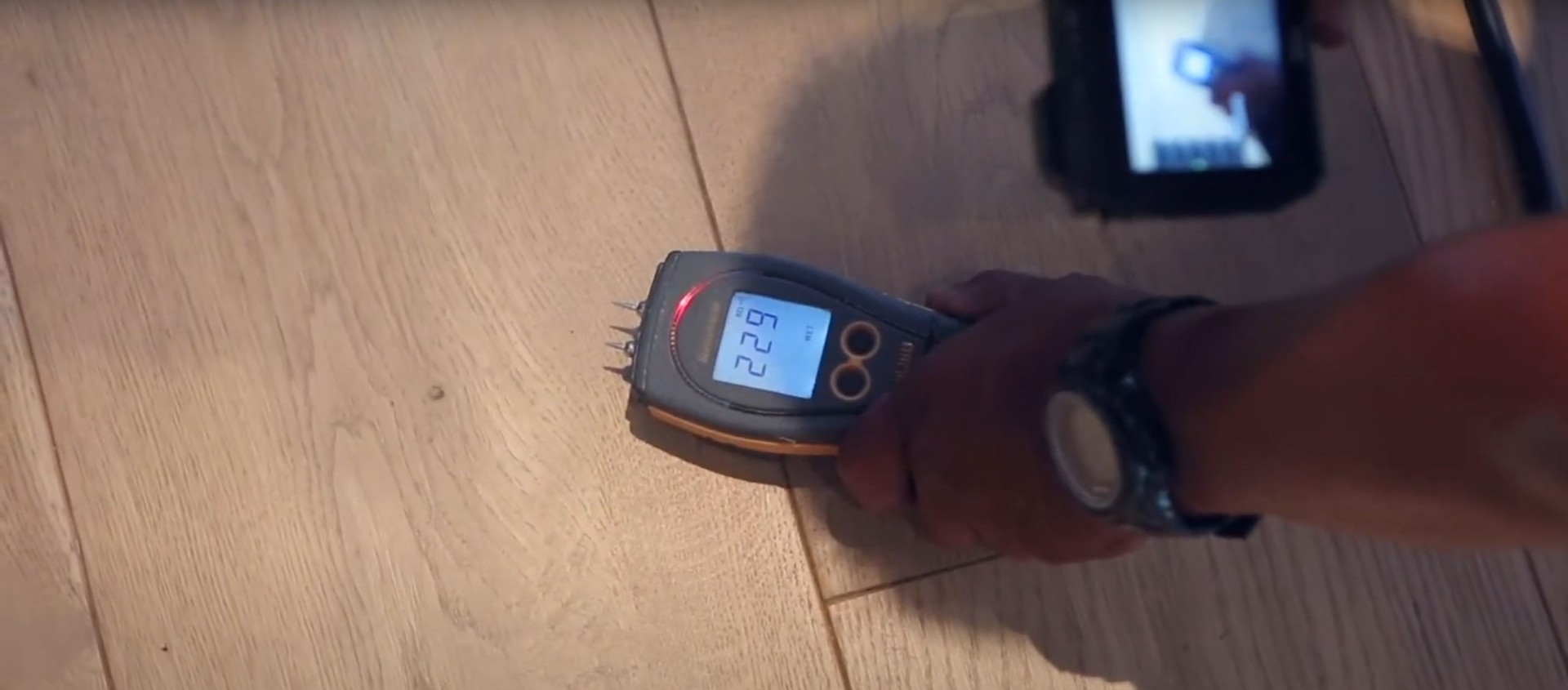 Advanced moisture detection and measurement tools used for accurate water damage assessment and documentation Professional moisture detection equipment showing readings on wooden floor surface during water damage assessment